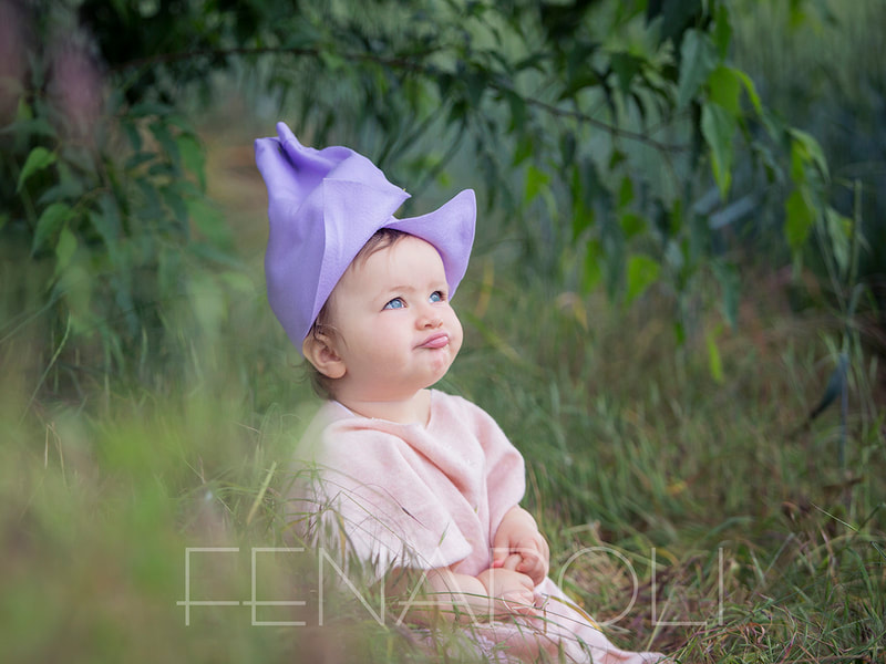 bambina con smorfia e cappellino lilla