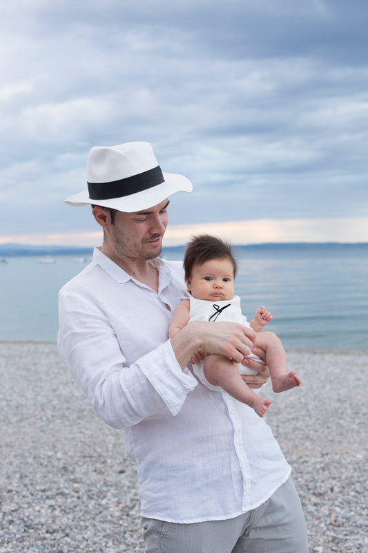papà con cappello e bebè al lago