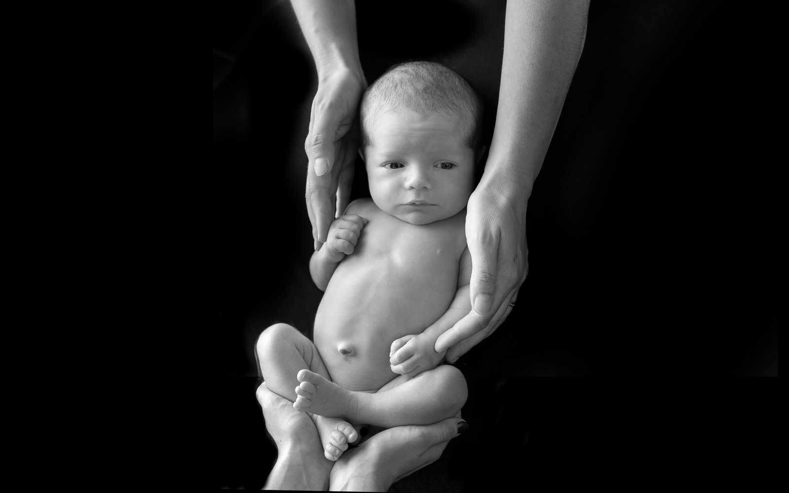 bimbo appena nato in braccio ai genitori fotografato nella sala da posa fenaroli atelier